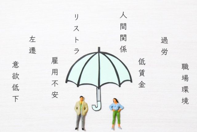 仕事に対する不満や不安が降り注ぐ中、傘で雨宿りする様子