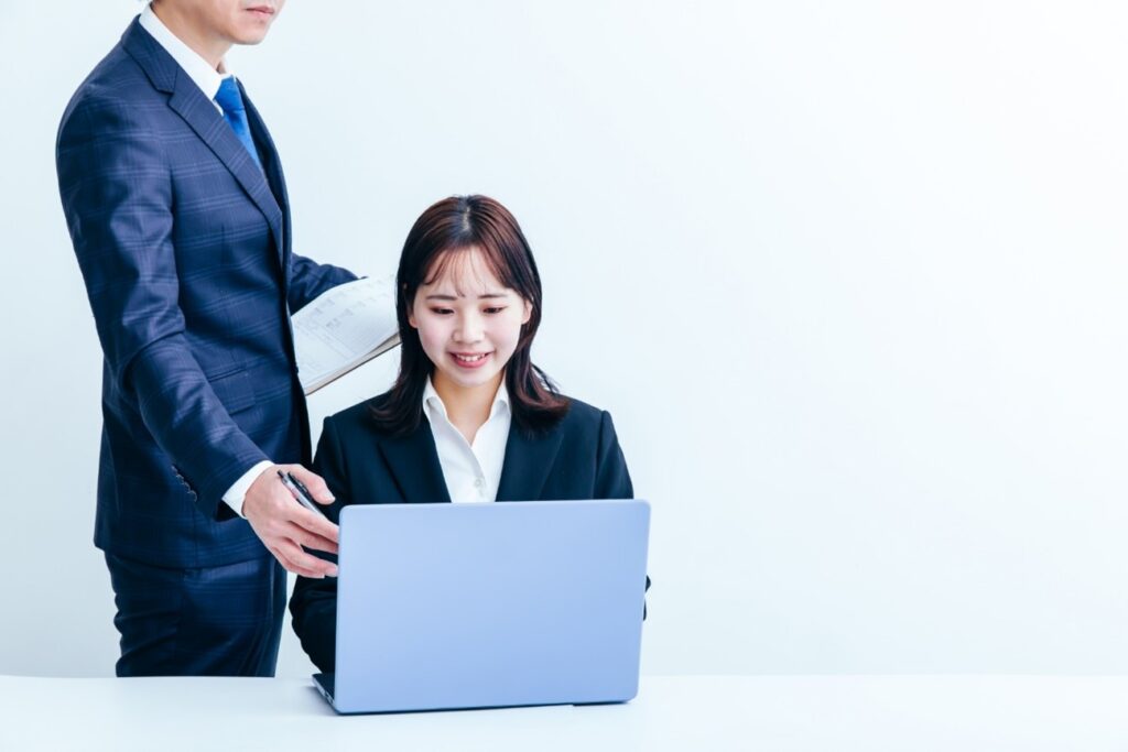 パソコンを操作する社員を指導する様子