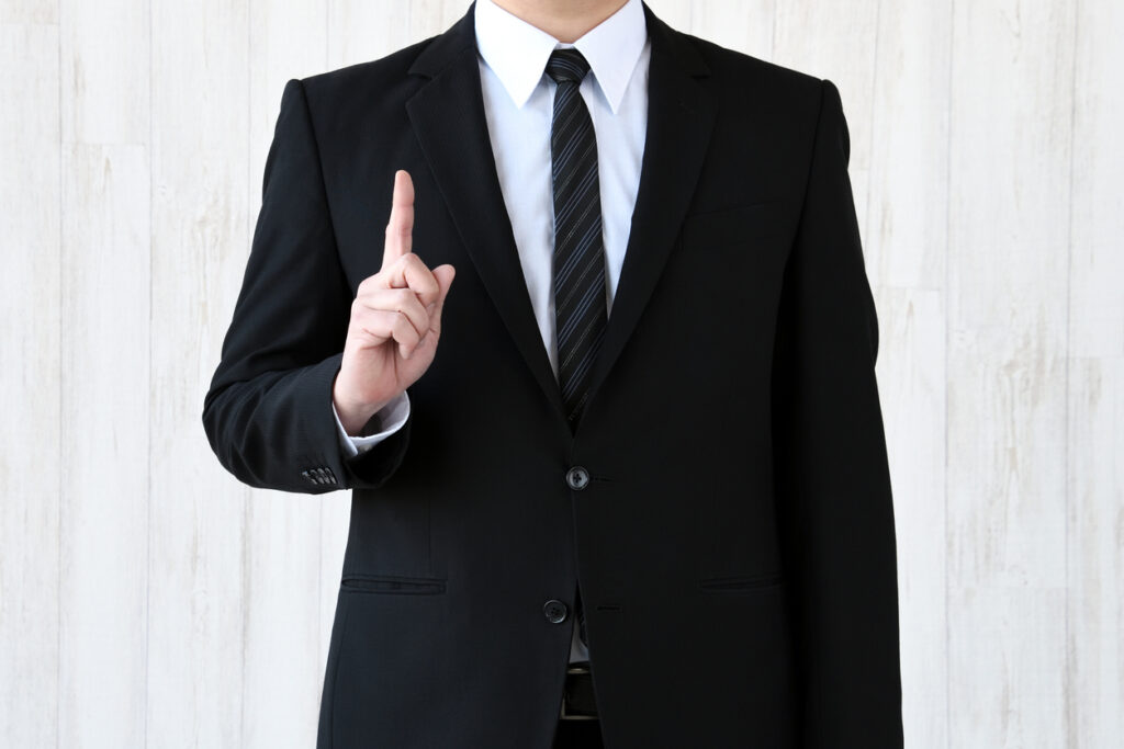ビジネスマンが人差し指を立てている様子