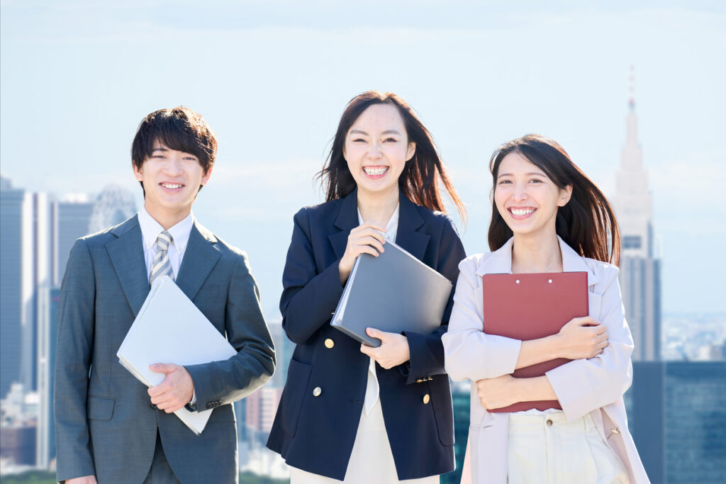 オフィス街を歩く3人のビジネスパーソンの姿