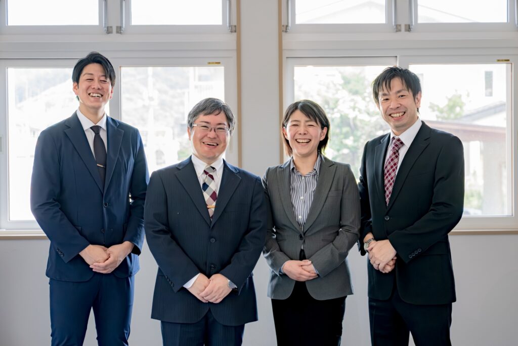 微笑む4人のビジネスパーソンの姿